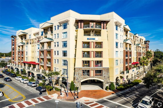 Front view of a multi-story apartment building at a street intersection.