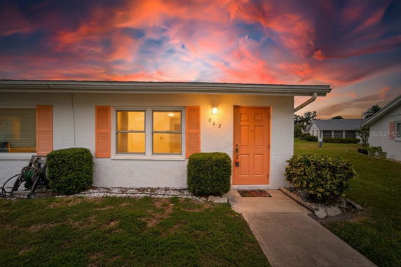 Front view of a house with a colorful sky at sunset.