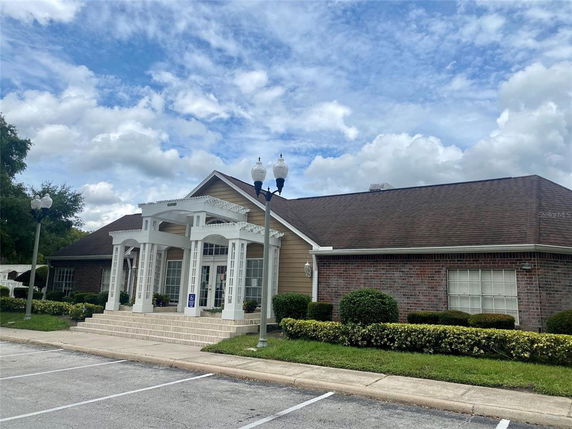 Front view of a single-story building with a gabled roof and a decorative entrance featuring white columns.