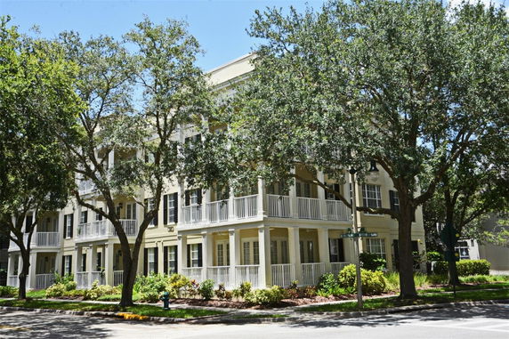Front view of a multi-story building with a light facade and multiple balconies.
