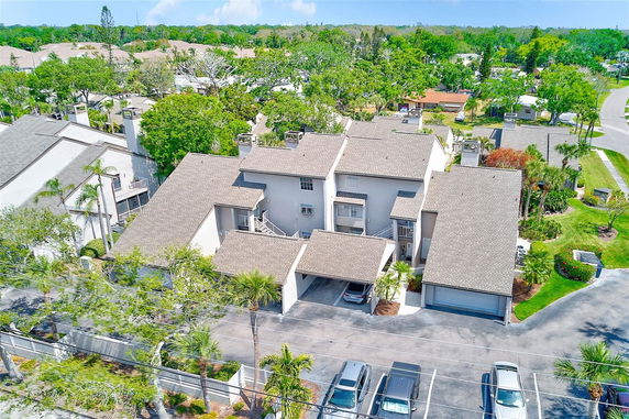 Front view of a multi-story residential building with garages and parking spaces.