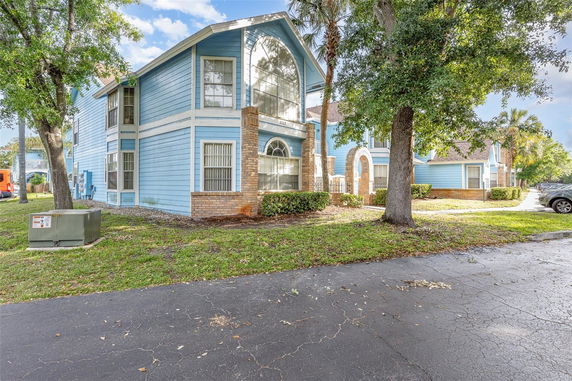 Front view of a two-story house with blue siding and brick accents.