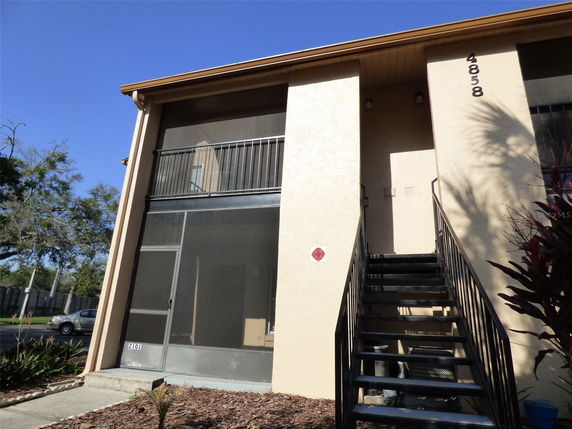 Front view of a two-story building with an external staircase.