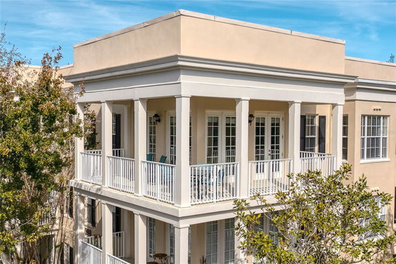 Front view of a two-story house with balconies and a flat roof.