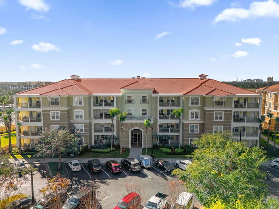 Front view of a multi-story residential building with a red tiled roof and balconies.