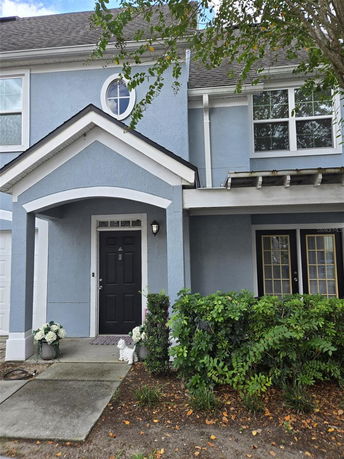 Front view of a two-story house with a blue exterior and a black front door.
