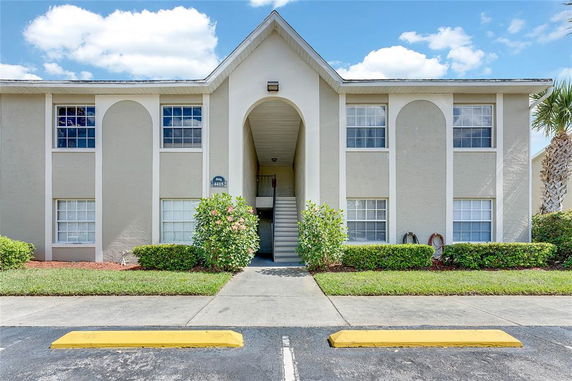 Front view of a multi-story residential building with an arched central entrance.