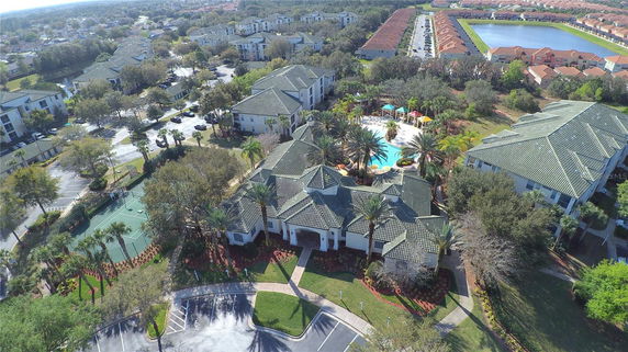 Aerial panoramic view of a residential area with buildings and a swimming pool.