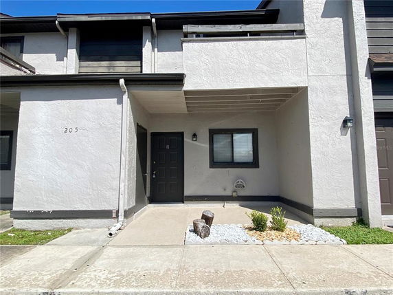 Front view of a two-story townhouse with an entryway and a window next to the door.