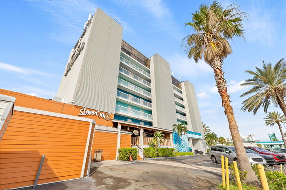 Front view of a multi-story building with a modern facade and adjacent outdoor area.