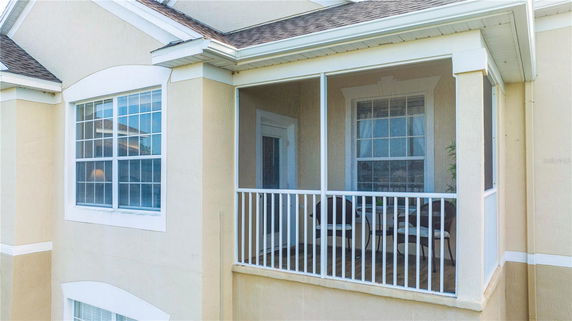 Front view of an upper-floor section of a house with a small screened balcony.