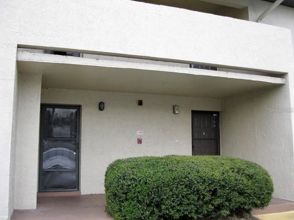 Front view of a building with two entrance doors and a balcony above.