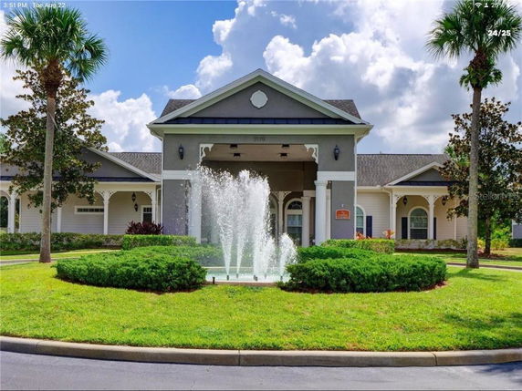 Front view of a single-story building with decorative columns and a central fountain.