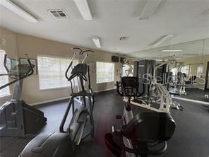 Indoor gym area with exercise equipment and large mirrors.