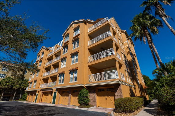 Front view of a multi-story apartment building with balconies and garages.