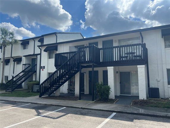 Front view of a two-story residential building with external staircases.