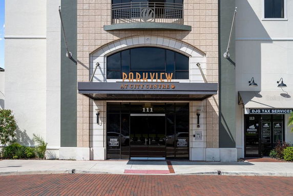 Front view of a commercial building with arched entrance and large windows.