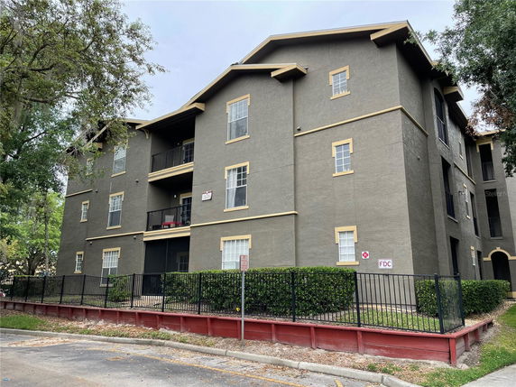 Front view of a multi-story apartment building with a dark facade and contrasting trim.