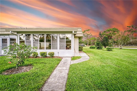 Front view of a single-story house with large windows and a walkway leading to the entrance.