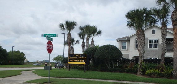 Front view of a multi-story condominium building with palm trees.