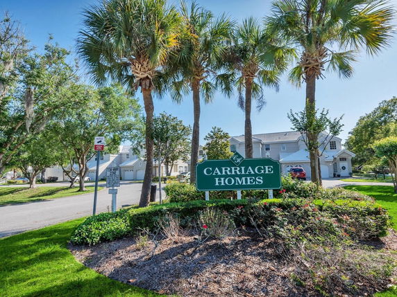 Front view of a residential complex with a sign reading 'Carriage Homes.'