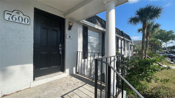 Front view of a house entrance with a black door and a small porch.