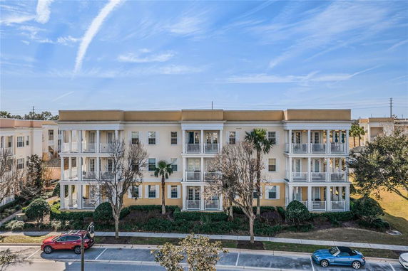 Front view of a three-story apartment building with balconies.