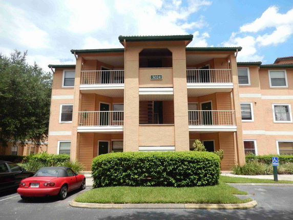 Front view of a three-story apartment building with balconies.