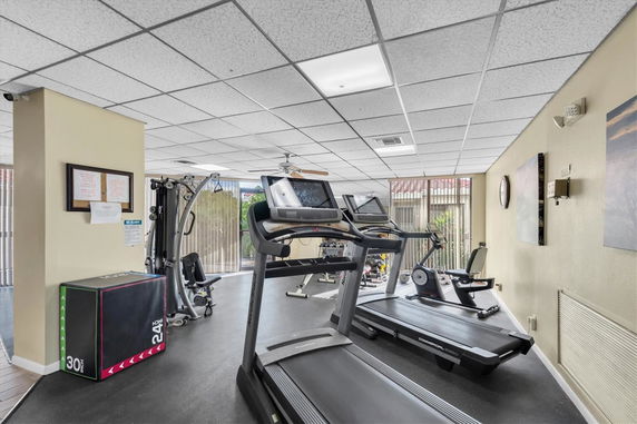 Indoor gym area with exercise equipment including treadmills and weight machines.