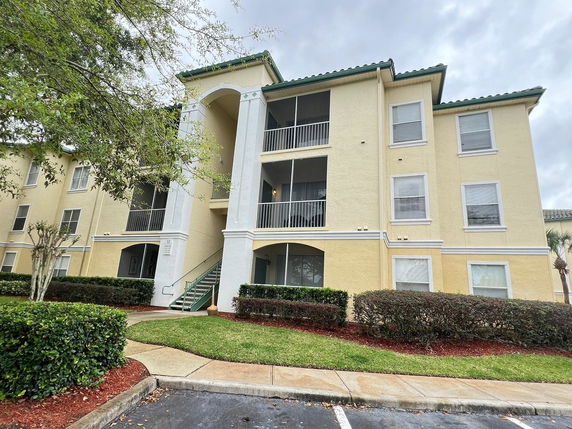 Front view of a three-story apartment building with balconies.