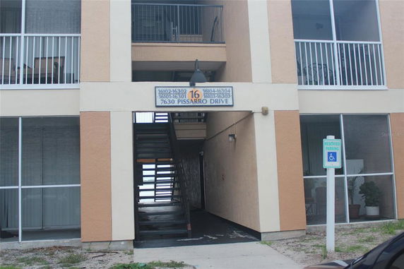 Front view of a multi-story building with stair access and balcony railings.