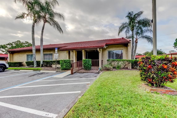 Front view of a single-story building with a red tiled roof and accessible entrance.