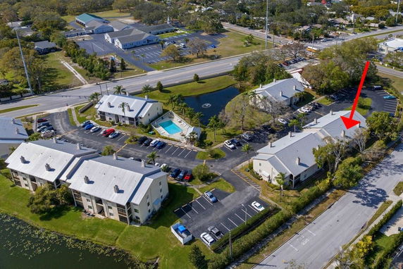 Aerial view of an apartment complex with parking areas and a swimming pool.