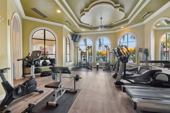 Interior view of a gym with exercise equipment and arched windows.