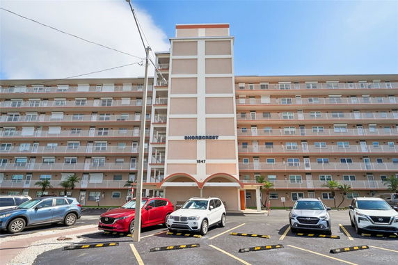Front view of a multi-story building with parking area.