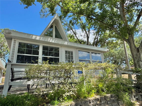 Front view of a house with large windows and a triangular roof section.