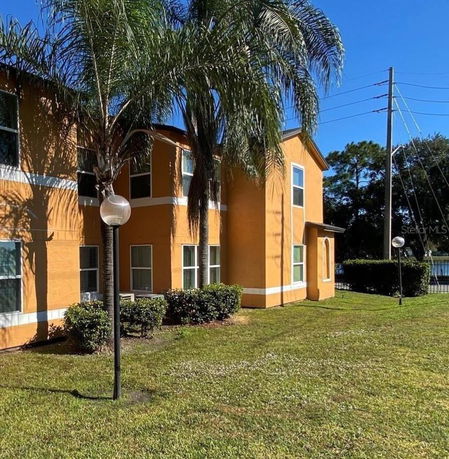 Front view of a two-story building with yellow exterior and multiple windows.