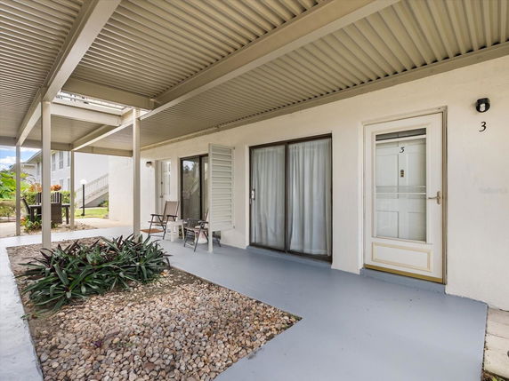 Front view of a house with a covered porch and sliding glass door.