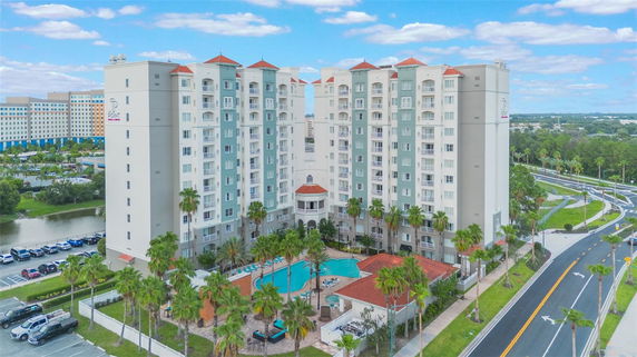 Front view of a multi-story building complex with a central swimming pool area.
