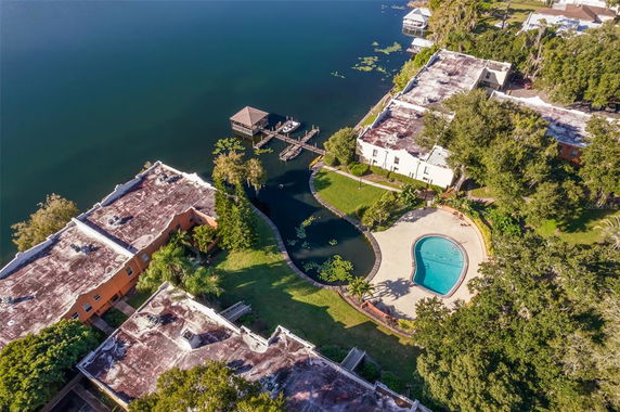 Aerial view of a residential area with a swimming pool and a lake.