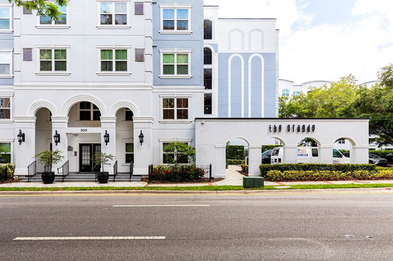 Front view of a multi-story building with archways and windows.