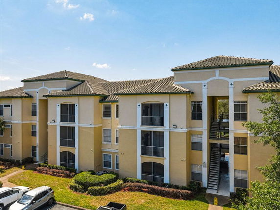 Front view of a multi-story apartment building with tiled roofs and balconies.
