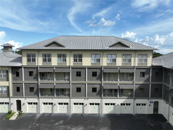 Front view of a multi-story apartment building with garages.