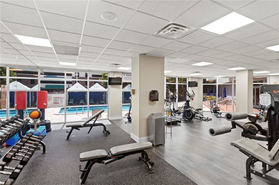 Indoor gym area with exercise equipment and large windows.