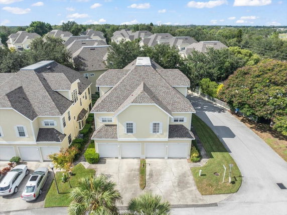 Front view of a multi-story house with multiple garages and a gabled roof.