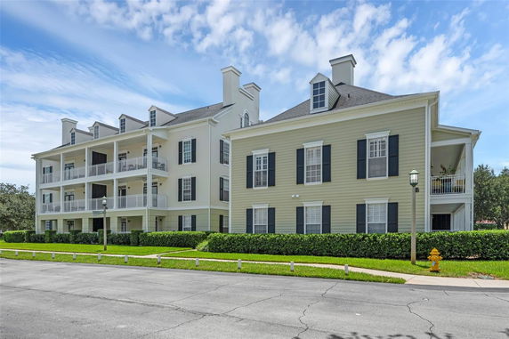 Front view of a multi-story residential building with balconies and chimneys.