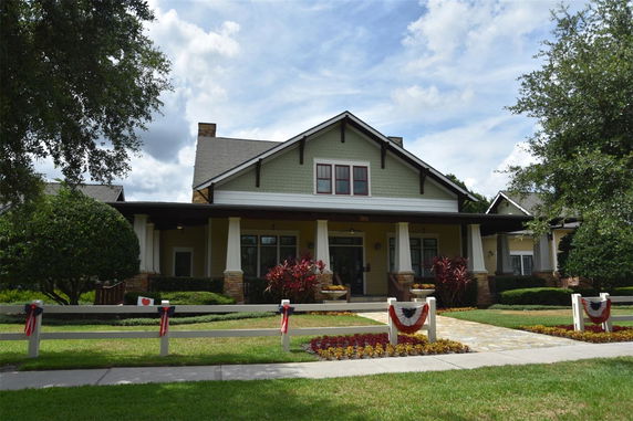 Front view of a single-story house with a covered porch and decorative pillars.