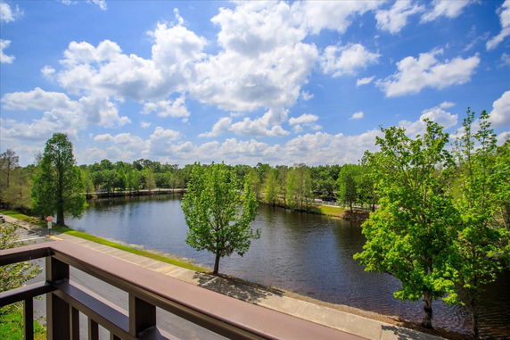 Panoramic view of a lake and trees from a balcony.