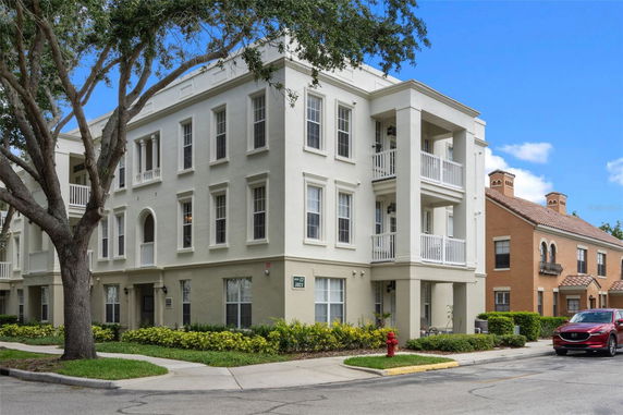 Front view of a three-story building with balconies and large windows.