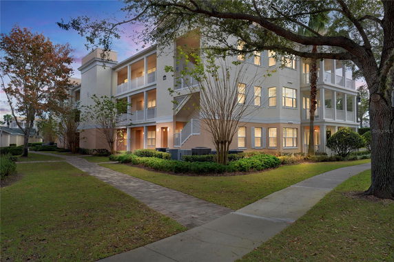 Front view of a multi-story building with balconies and lit windows.